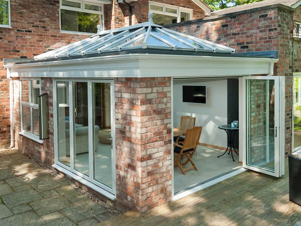 A white conservatory with bi-folding doors